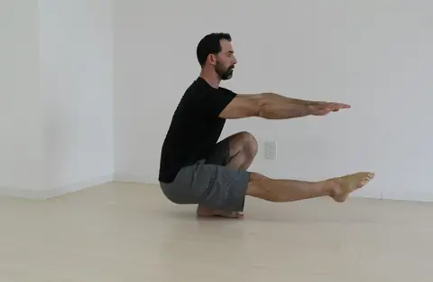 A man holding a deep single-leg squat as a mobility drill